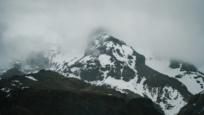 severe snowy mountains under thick clouds